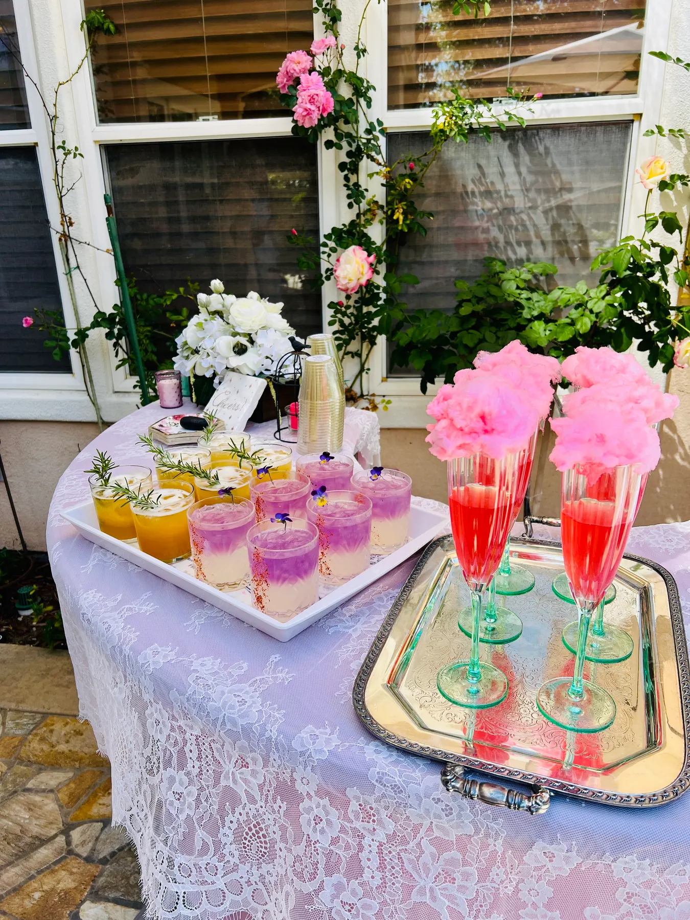 Party drink station with pink cotton candy mocktails and sparkling glasses on a lace-draped table